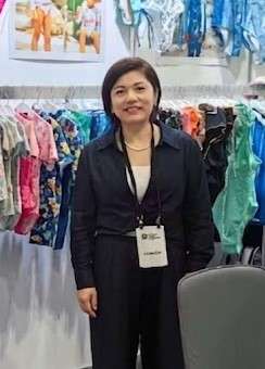 Lily Yu, General Manager of YucaiFJ swimwear manufacturer, reviewing private label swimwear samples at a trade show